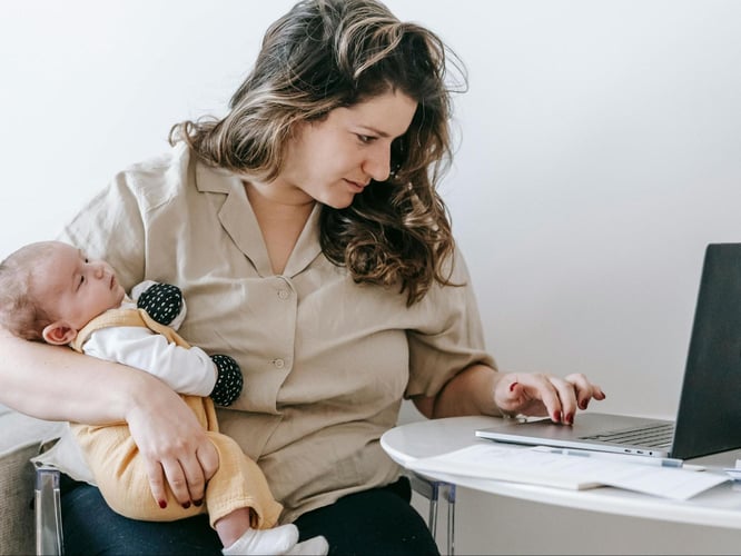 mom holding a child while working